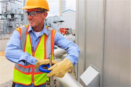 Engineer at electric power plant turning a gate valve on a pipe to the water storage tank Stock Photo - Premium Royalty-Free, Code: 6105-07521486