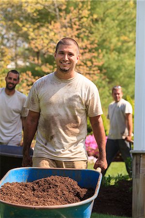 Landscapers carrying mulch to a garden in wheelbarrow Photographie de stock - Premium Libres de Droits, Code: 6105-07521420