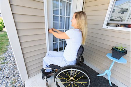 scarborough - Woman with spinal cord injury in wheelchair locking her front door Photographie de stock - Premium Libres de Droits, Code: 6105-07744367