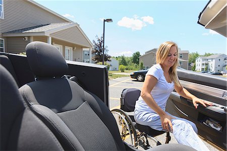 disabled person in wheelchair - Woman with spinal cord injury in wheelchair entering in her adaptive car Stock Photo - Premium Royalty-Free, Code: 6105-07744368