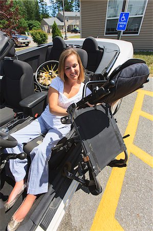 simsearch:6105-07744367,k - Woman with spinal cord injury pulling chair from wheelchair into her adaptive vehicle Foto de stock - Sin royalties Premium, Código: 6105-07744369