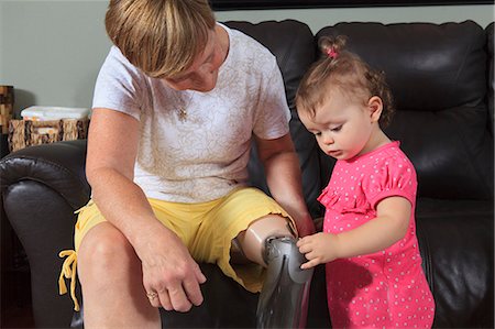 disability - Grandmother with prosthetic leg with her grandchild playing with the prosthesis Foto de stock - Sin royalties Premium, Código: 6105-07744376