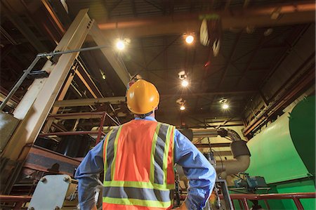 Engineer in electric power plant studying movement of overhead crane Stock Photo - Premium Royalty-Free, Code: 6105-07744449