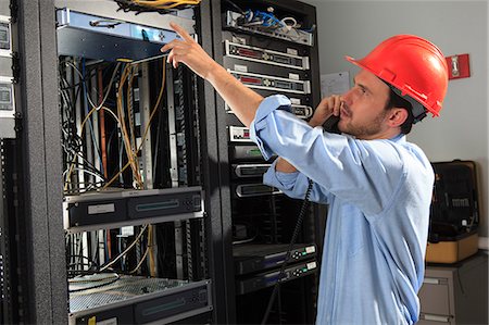 Network engineer on phone performing trouble shooting Stock Photo - Premium Royalty-Free, Code: 6105-07744483