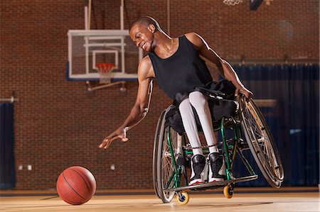 simsearch:6105-07744517,k - Man who had Spinal Meningitis in wheelchair reaching for basketball Fotografie stock - Premium Royalty-Free, Codice: 6105-07744402