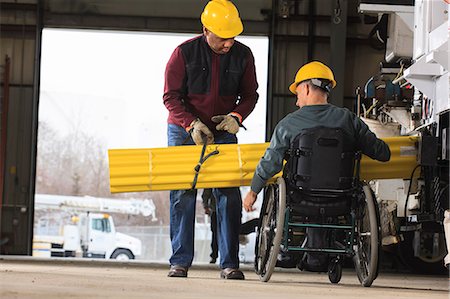 Maintenance supervisors one with spinal cord injury loading shielding onto utility truck Photographie de stock - Premium Libres de Droits, Code: 6105-07744438