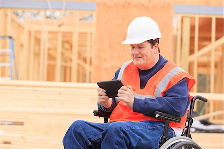 simsearch:6105-07744461,k - Construction engineer with spinal cord injury using tablet to take notes on site Stock Photo - Premium Royalty-Free, Code: 6105-07744509