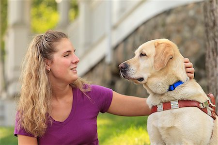 Woman with visual impairment petting her service dog Foto de stock - Sin royalties Premium, Código: 6105-08211242