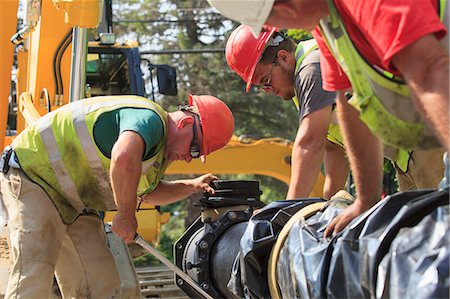 Construction workers using torque wrench to secure water main section with bolts Stock Photo - Premium Royalty-Free, Code: 6105-08211259