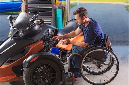 simsearch:6105-07744461,k - Man with spinal cord injury building his custom motorcycle Stock Photo - Premium Royalty-Free, Code: 6105-08211268