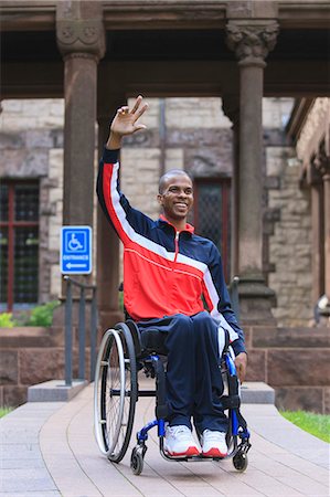 Man in wheelchair with Spinal Meningitis using a ramp and waving Stock Photo - Premium Royalty-Free, Code: 6105-08211226