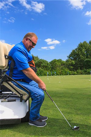 simsearch:6105-05396581,k - Man with a spinal cord injury in an adaptive cart at golf putting green Photographie de stock - Premium Libres de Droits, Code: 6105-08211341