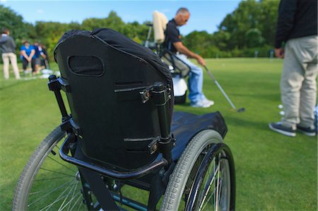 simsearch:6105-07744377,k - Man with a spinal cord injury in an adaptive cart at golf putting green with an instructor Stockbilder - Premium RF Lizenzfrei, Bildnummer: 6105-08211344