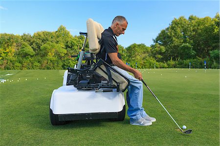 simsearch:6105-08211342,k - Man with a spinal cord injury in an adaptive cart at golf putting green Photographie de stock - Premium Libres de Droits, Code: 6105-08211346
