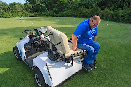simsearch:6105-08211342,k - Man with a spinal cord injury in an adaptive golf cart getting into his wheelchair Photographie de stock - Premium Libres de Droits, Code: 6105-08211348