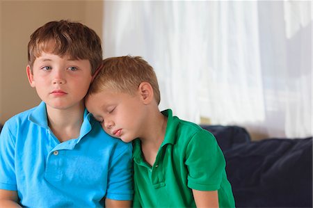 Boys with hearing impairments sitting on their couch Stock Photo - Premium Royalty-Free, Code: 6105-08211321