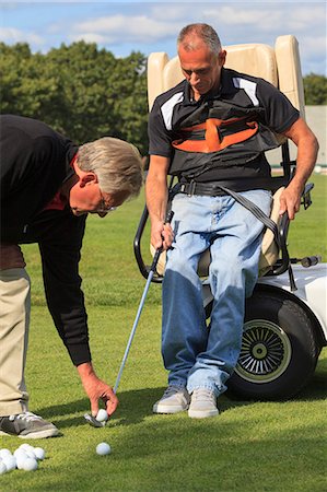 simsearch:6105-08211342,k - Instructor placing golf ball for man with a spinal cord injury Photographie de stock - Premium Libres de Droits, Code: 6105-08211334
