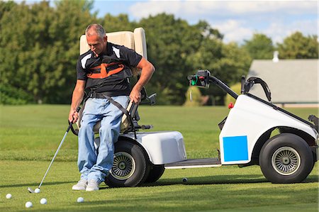 simsearch:6105-08211342,k - Man with a spinal cord injury in an adaptive cart for playing golf Photographie de stock - Premium Libres de Droits, Code: 6105-08211335