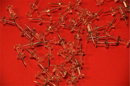 Pushpins on red background Stock Photo - Premium Royalty-Free, Code: 6107-06117480