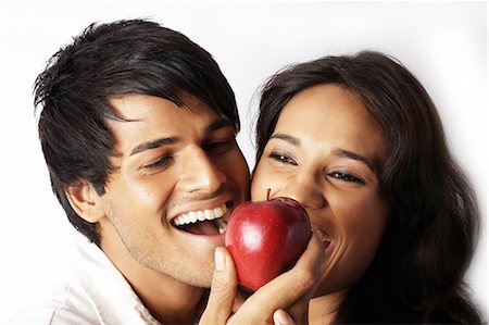 feeding food to lover images - Close-up of young man feeding apple to young woman Stock Photo - Premium Royalty-Free, Code: 6107-06117502