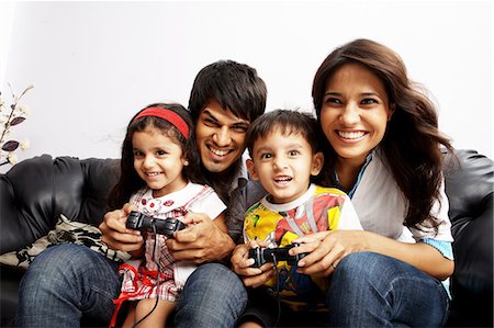 Portrait de parents assis avec leurs enfants et jouer au jeu vidéo Photographie de stock - Premium Libres de Droits, Code: 6107-06117606