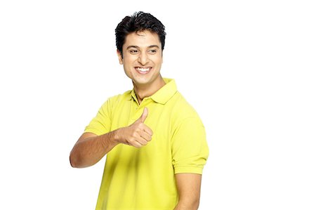 Portrait of young man posing with thumb up Stock Photo - Premium Royalty-Free, Code: 6107-06117634
