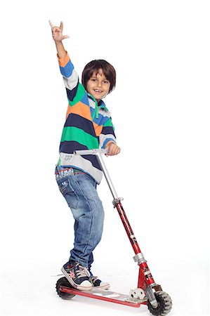 Portrait du petit garçon avec pied pousser skate cycle Photographie de stock - Premium Libres de Droits, Code: 6107-06117703