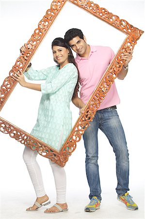 family portraits in frames - Portrait d'un couple heureux tenant un cadre Photographie de stock - Premium Libres de Droits, Code: 6107-06117872