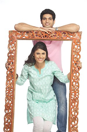 family portraits in frames - Portrait d'un couple heureux avec un cadre Photographie de stock - Premium Libres de Droits, Code: 6107-06117874