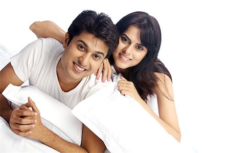 Portrait of a happy couple with pillows Stock Photo - Premium Royalty-Free, Code: 6107-06117917