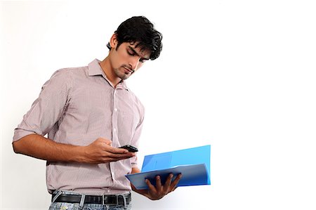 Portrait of man holding file and texting on mobile Stock Photo - Premium Royalty-Free, Code: 6107-06117936