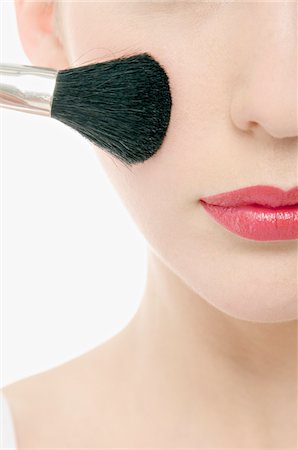 face powder - Young Woman face with Make-Up, holding  a brush in front of her, close-up (studio) Foto de stock - Sin royalties Premium, Código: 6108-05855609