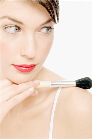 Young Woman with Make-Up holding a brush, close-up (studio) Stock Photo - Premium Royalty-Free, Code: 6108-05855613
