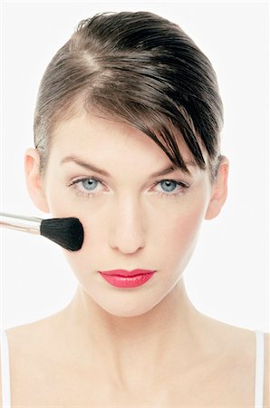 polvos de colorete - Young Woman face making-up with a brush, close-up (studio) Foto de stock - Sin royalties Premium, Código: 6108-05855615