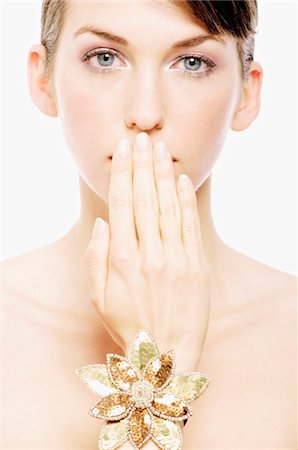 Visage de la jeune femme avec composent, ayant sa main devant sa bouche, close-up (studio) Photographie de stock - Premium Libres de Droits, Code: 6108-05855624