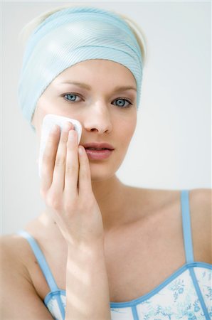 simsearch:6108-05855735,k - Young Woman face using a cleansing cotton on her cheek, close-up (studio) Stock Photo - Premium Royalty-Free, Code: 6108-05855748