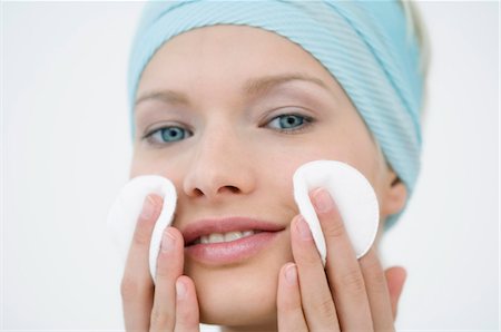 face washing - Young Woman face using a cleansing cotton on her cheeks, close-up (studio) Stock Photo - Premium Royalty-Free, Code: 6108-05855750