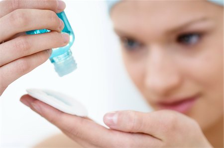 Young Woman face pouring on lotion in her hand, close-up (studio) Stock Photo - Premium Royalty-Free, Code: 6108-05855754