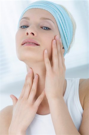 simsearch:614-06442343,k - Young Woman looking at the camera, putting her hands on her neck close-up (studio) Stock Photo - Premium Royalty-Free, Code: 6108-05855726