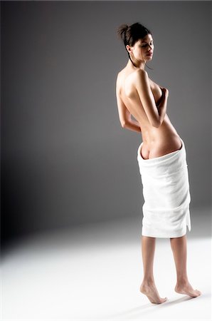 Femme nue, vue de l'arrière, serviette de bain sur ses fesses (studio) Photographie de stock - Premium Libres de Droits, Code: 6108-05855885