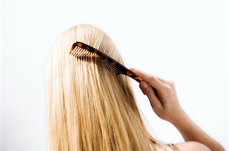 simsearch:6108-05855819,k - Portrait d'une jeune femme peignant ses cheveux, vue de dos Photographie de stock - Premium Libres de Droits, Code: 6108-05855823