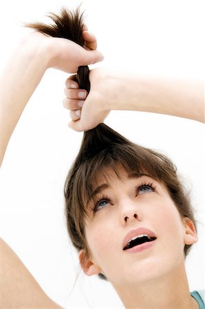 simsearch:6108-05873483,k - Porträt einer jungen Frau ziehen ihr Haar, close up (Studio) Stockbilder - Premium RF Lizenzfrei, Bildnummer: 6108-05855834