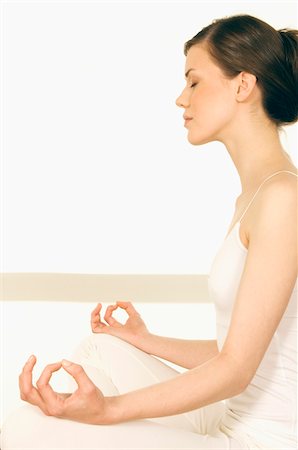 Young woman sitting in profile, yoga attitude Stock Photo - Premium Royalty-Free, Code: 6108-05855941