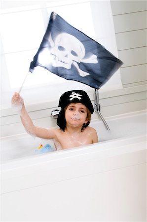 Little boy in bath holding pirate flag Stock Photo - Premium Royalty-Free, Code: 6108-05856067