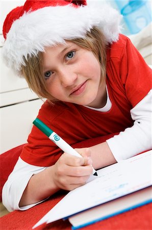 Boy disguised as Santa Claus, writing Stock Photo - Premium Royalty-Free, Code: 6108-05856070