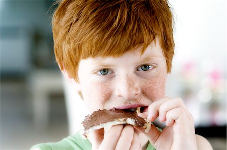 Portrait d'un petit garçon manger une tranche de pain et chocolat Photographie de stock - Premium Libres de Droits, Code: 6108-05856076