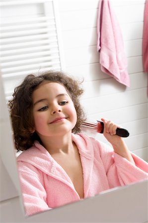 Little girl in bathroom brushing her hair Stock Photo - Premium Royalty-Free, Code: 6108-05856138