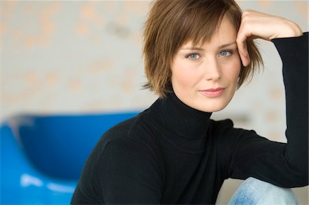 sweaters turtleneck - Young woman sitting on the floor, looking at the camera Stock Photo - Premium Royalty-Free, Code: 6108-05856496