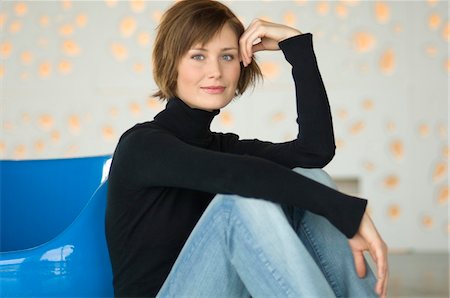 sweaters turtleneck - Young woman sitting on the floor, looking at the camera Stock Photo - Premium Royalty-Free, Code: 6108-05856436