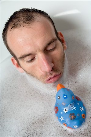 floating (object on water) - Man having a bath, playing with a plastic duck Stock Photo - Premium Royalty-Free, Code: 6108-05856561